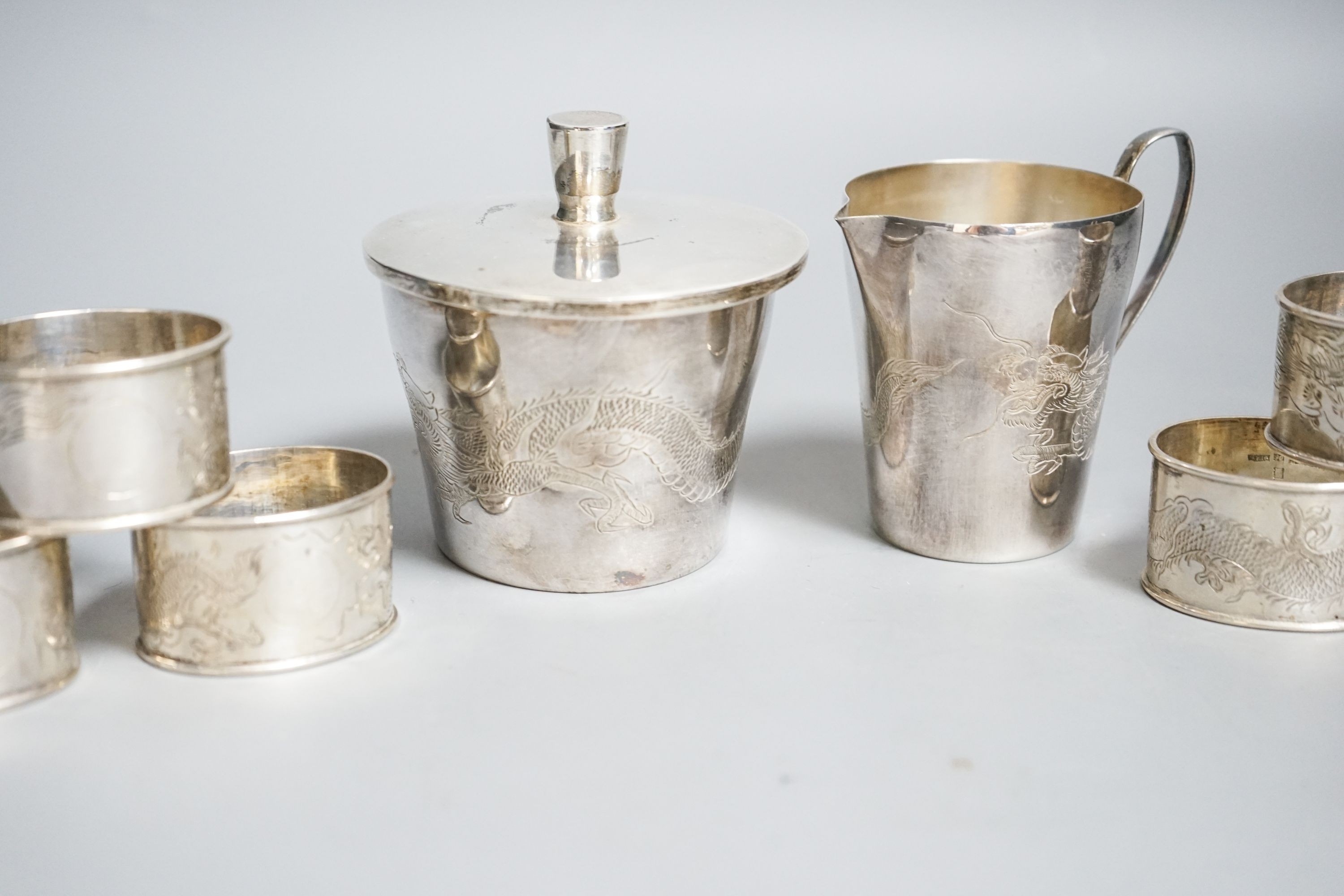 A Chinese sterling pot and cover by Kingsburg, Hong Kong, 9.4cm, a similar cream jug and six napkin rings by Wang Hing
